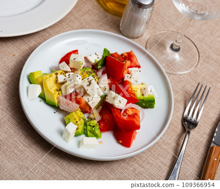 Fresh salad with avocado, tomatoes, cheese and onion closeup Fresh salad with avocado, tomatoes, cheese and onion closeup 109366954