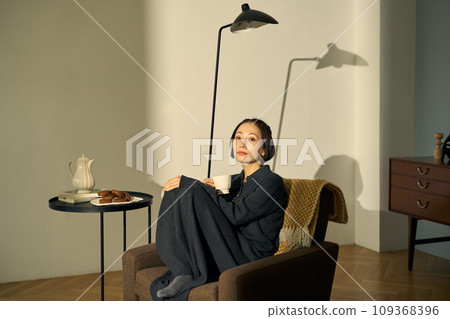 日落時在沙發上放鬆的女人 日落時在沙發上放鬆的女人 109368396