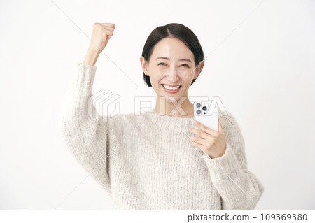 一名中年婦女拿著智慧型手機，握拳，白色背景 109369380
