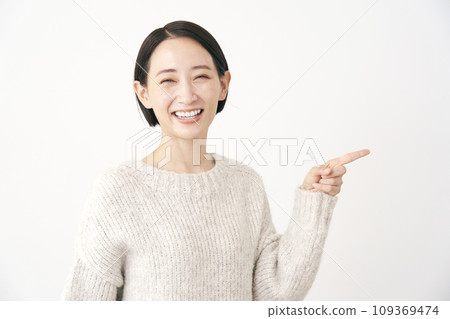 Middle-aged woman pointing to the right White background Middle-aged woman pointing to the right White background 109369474