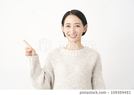 Middle-aged woman pointing to the left White background Middle-aged woman pointing to the left White background 109369481