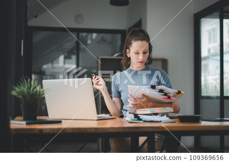 Business woman using business paper for doing math finance on office desk, tax, report, accounting, statistics, and analytical research concept 109369656