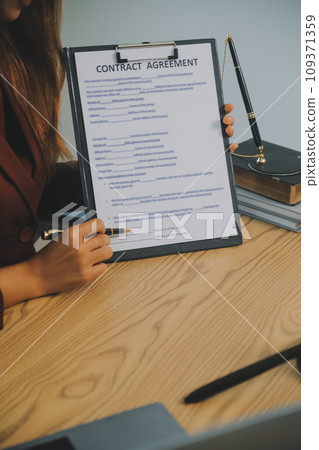 Lawyer, legal advisor, businessman brainstorming information on agreement details Business contracts in legal processing books for accuracy in contract documents. joint financial investment. 109371359