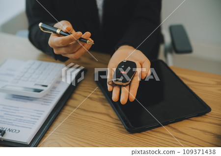 Salesman send key to customer after good deal agreement, successful car loan contract buying or selling new vehicle. Salesman send key to customer after good deal agreement, successful car loan contract buying or selling new vehicle. 109371438