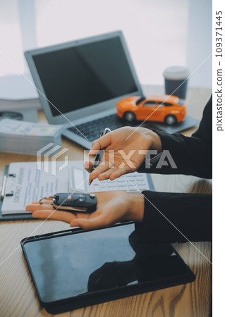 Salesman send key to customer after good deal agreement, successful car loan contract buying or selling new vehicle. Salesman send key to customer after good deal agreement, successful car loan contract buying or selling new vehicle. 109371445