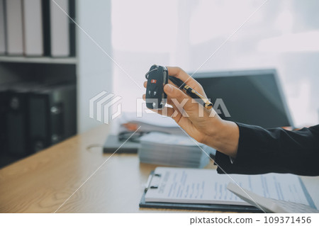 Salesman send key to customer after good deal agreement, successful car loan contract buying or selling new vehicle. Salesman send key to customer after good deal agreement, successful car loan contract buying or selling new vehicle. 109371456