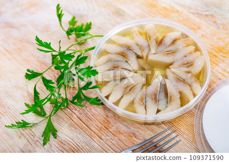 Marinated herring with onions and spice in plastic jar Marinated herring with onions and spice in plastic jar 109371590