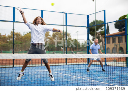 Caucasian man playing paddle tennis on padel court Caucasian man playing paddle tennis on padel court 109371689