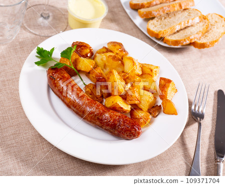 Traditional Spanish dish with sausages served with potatoes and spicy aioli closeup Traditional Spanish dish with sausages served with potatoes and spicy aioli closeup 109371704