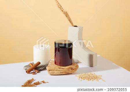 Front view of an unbranded jar of scrubs is placed on a stone platform. Cosmetic concept extracted from rice bran. Rice bran is used to remove dead cells from the skin. 109372055