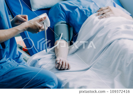 Side view of diverse doctors examining Asian female patient in bed in ward at hospital. Side view of diverse doctors examining Asian female patient in bed in ward at hospital. 109372416