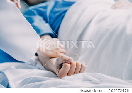 Side view of diverse doctors examining Asian female patient in bed in ward at hospital. Side view of diverse doctors examining Asian female patient in bed in ward at hospital. 109372476