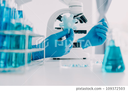 biochemical research scientist team working with microscope for coronavirus vaccine development in pharmaceutical research labolatory, selective focus 109372503