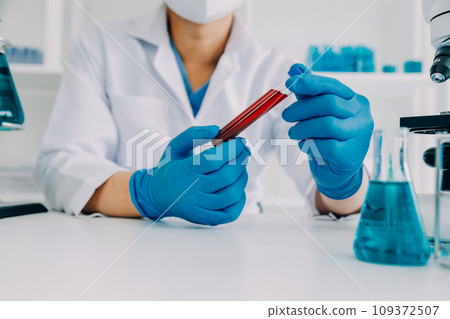 biochemical research scientist team working with microscope for coronavirus vaccine development in pharmaceutical research labolatory, selective focus 109372507