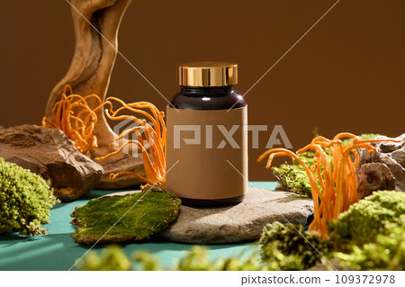 Mockup for drug advertising displayed on a stone platform with green moss and cordyceps. Selenium in cordyceps not only helps strengthen the body's resistance but can also help prevent cancer. 109372978