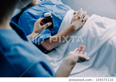 Doctor telling to patient woman the results of her medical tests. Doctor showing medical records to cancer patient in hospital ward. Senior doctor explaint the side effects of the intervention. 109373110