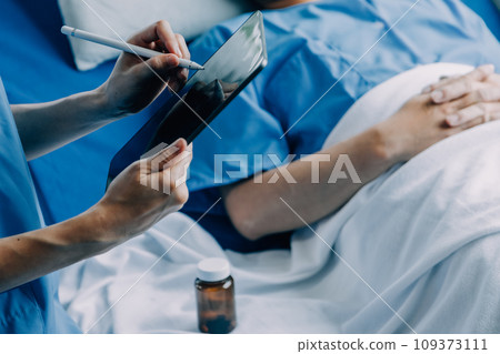 Doctor telling to patient woman the results of her medical tests. Doctor showing medical records to cancer patient in hospital ward. Senior doctor explaint the side effects of the intervention. 109373111