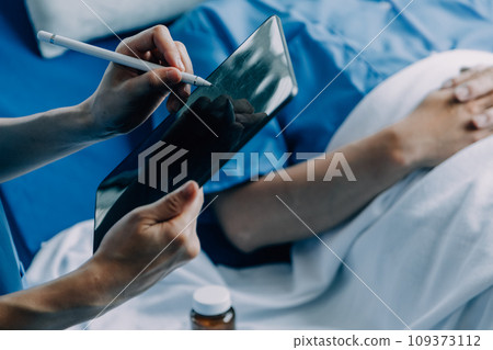Doctor telling to patient woman the results of her medical tests. Doctor showing medical records to cancer patient in hospital ward. Senior doctor explaint the side effects of the intervention. 109373112