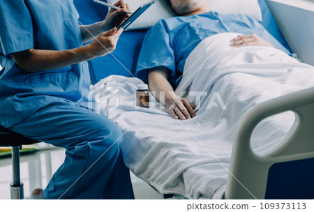 Doctor telling to patient woman the results of her medical tests. Doctor showing medical records to cancer patient in hospital ward. Senior doctor explaint the side effects of the intervention. 109373113