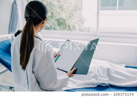 Doctor telling to patient woman the results of her medical tests. Doctor showing medical records to cancer patient in hospital ward. Senior doctor explaint the side effects of the intervention. 109373154