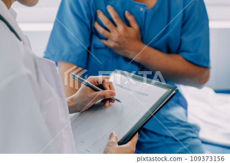 Doctor telling to patient woman the results of her medical tests. Doctor showing medical records to cancer patient in hospital ward. Senior doctor explaint the side effects of the intervention. 109373156
