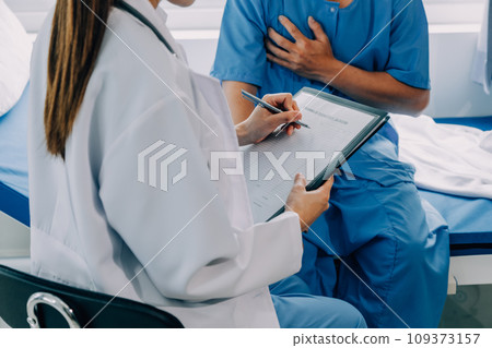 Doctor telling to patient woman the results of her medical tests. Doctor showing medical records to cancer patient in hospital ward. Senior doctor explaint the side effects of the intervention. 109373157