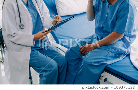 Doctor telling to patient woman the results of her medical tests. Doctor showing medical records to cancer patient in hospital ward. Senior doctor explaint the side effects of the intervention. 109373158