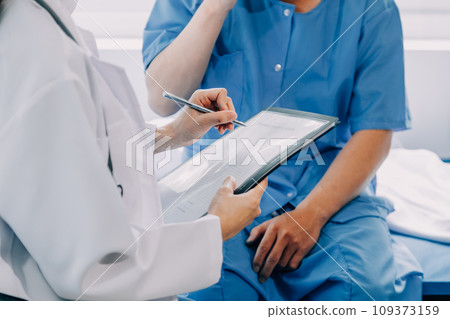 Doctor telling to patient woman the results of her medical tests. Doctor showing medical records to cancer patient in hospital ward. Senior doctor explaint the side effects of the intervention. 109373159