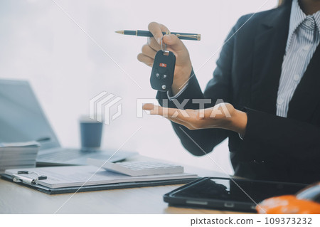 Salesman send key to customer after good deal agreement, successful car loan contract buying or selling new vehicle. 109373232