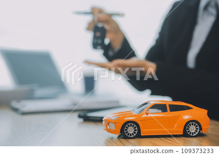 Salesman send key to customer after good deal agreement, successful car loan contract buying or selling new vehicle. Salesman send key to customer after good deal agreement, successful car loan contract buying or selling new vehicle. 109373233