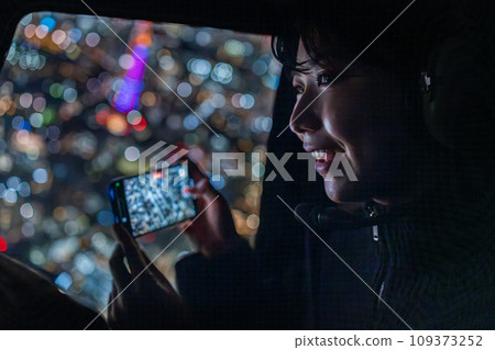 一位年輕女子用 IPHONE 拍攝東京夜景 一位年輕女子用 IPHONE 拍攝東京夜景 109373252