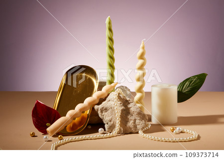 Artistic arrangement of twisted candles, a stone slab, and props on the backdrop. Candles commonly enhance aesthetics at parties and events. Copy space. 109373714