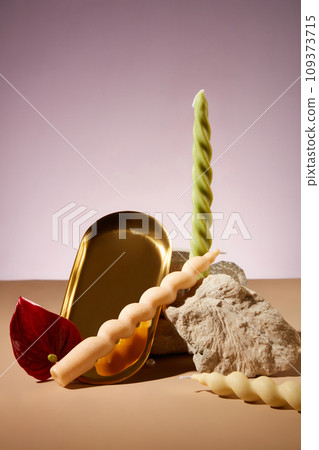 Twisted candles, a stone slab and props are artistically arranged on the background. Candles are commonly used at parties to increase aesthetics. 109373715