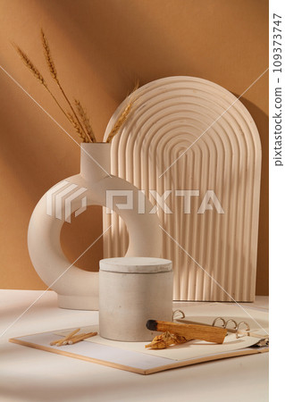 A jar of scented candles is displayed on a table with props. White-brown background. Mockup for advertising. Scented candles help eliminate unpleasant odors in the room. 109373747