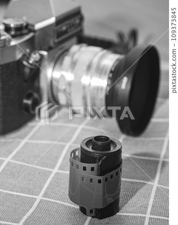 classic 135 film cassette with retro camera background   109373845