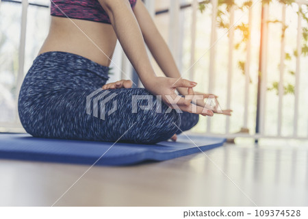 Women doing yoga hand in lotus position. Yoga fitness lifestyle healthy woman relaxation doing meditation. Yoga woman workout in sportswear sit on yoga mat home fitness workout exercise. Home fitness 109374528