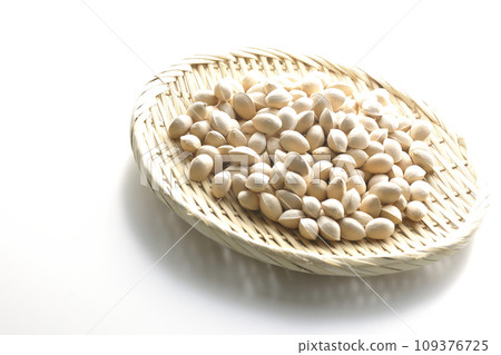 A photo of ginkgo seeds in a basket against a white background 109376725