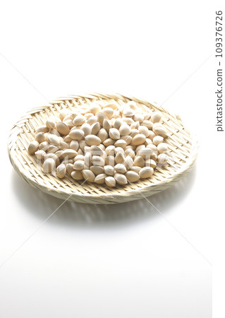 A photo of ginkgo seeds in a basket against a white background 109376726