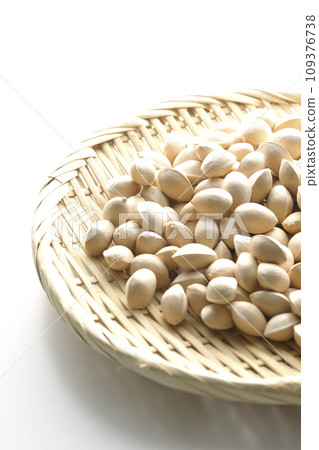 A photo of ginkgo seeds in a basket against a white background 109376738