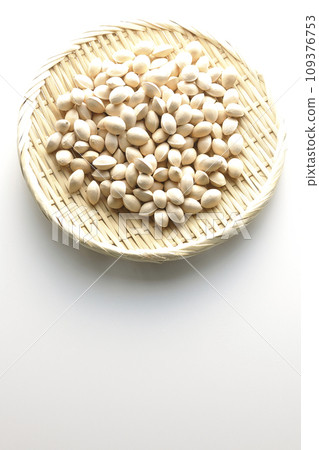 An overhead shot of ginkgo seeds in a basket against a white background 109376753