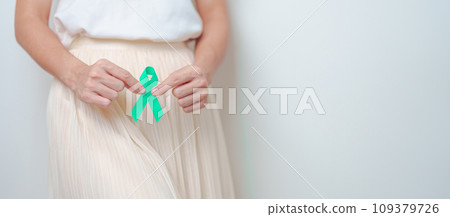 Woman holding Teal Ribbon on abdomen for January Cervical Cancer Awareness month. Uterus and Ovaries, Cervix, Endometriosis, Hysterectomy, Uterine fibroids, Reproductive and World cancer day concept Woman holding Teal Ribbon on abdomen for January Cervical Cancer Awareness month. Uterus and Ovaries, Cervix, Endometriosis, Hysterectomy, Uterine fibroids, Reproductive and World cancer day concept 109379726