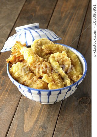 A tempura bowl with lots of toppings, including shrimp, chikuwa, green beans, pumpkin, sweet potato, and lotus root. 109380951