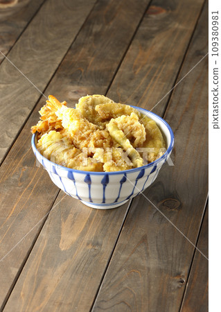 A tempura bowl with lots of toppings, including shrimp, chikuwa, green beans, pumpkin, sweet potato, and lotus root. 109380981