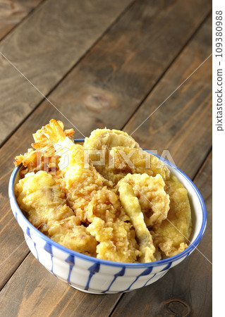 天婦羅碗裡有許多配料,包括蝦子、竹輪、青豆、南瓜、地瓜和蓮藕。 天婦羅碗裡有許多配料,包括蝦子、竹輪、青豆、南瓜、地瓜和蓮藕。 109380988