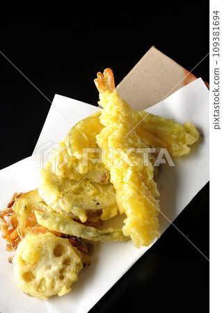 An overhead shot of assorted shrimp, chikuwa, green beans, pumpkin, sweet potato, and lotus root tempura against a black background An overhead shot of assorted shrimp, chikuwa, green beans, pumpkin, sweet potato, and lotus root tempura against a black background 109381694