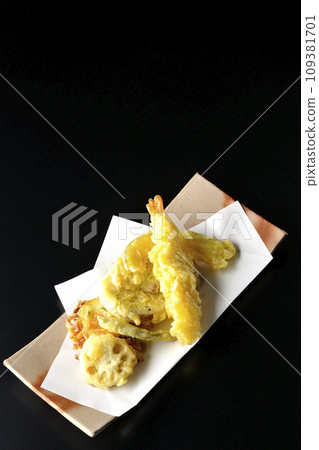 An overhead shot of assorted shrimp, chikuwa, green beans, pumpkin, sweet potato, and lotus root tempura against a black background An overhead shot of assorted shrimp, chikuwa, green beans, pumpkin, sweet potato, and lotus root tempura against a black background 109381701