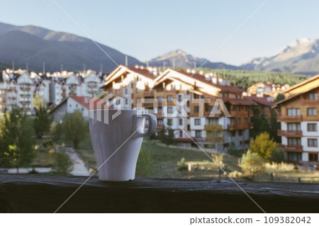a cup of tea against the backdrop of the hotel and beautiful mountains in Bansko, Bulgaria a cup of tea against the backdrop of the hotel and beautiful mountains in Bansko, Bulgaria 109382042