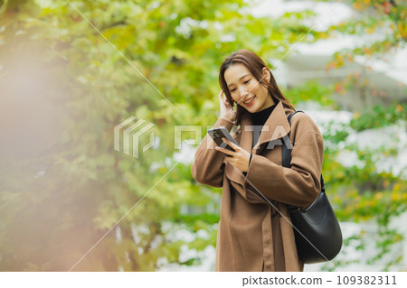 穿著外套在戶外散步的女人 穿著外套在戶外散步的女人 109382311