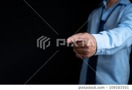 Employee makes a forward pointing gesture on a dark background. 109383501