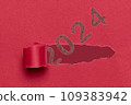 2024, Number 2024 appearing through the tear in a red cardboard. Happy New Year 109383942